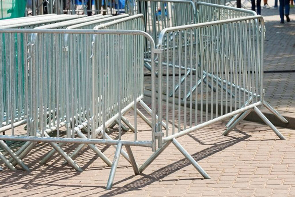 Stainless steel crowd control barricades lined up for an outdoor event.