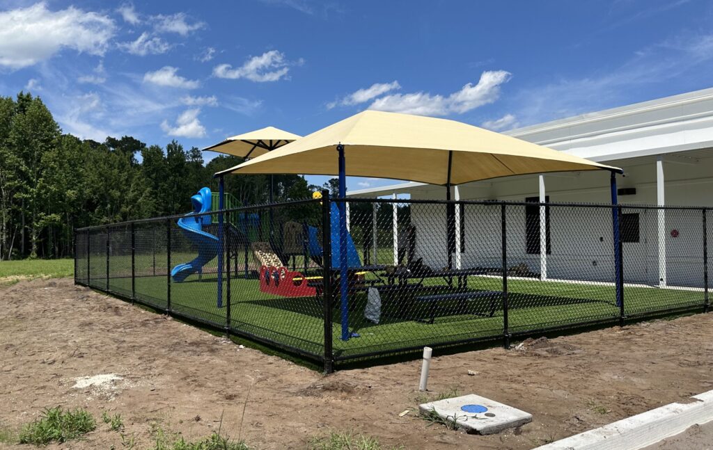 Chain link fence around colorful outdoor play area.